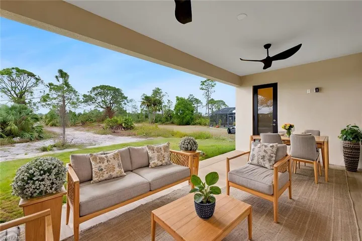 View of patio / terrace featuring an outdoor living space, ceiling fan, and glass enclosure