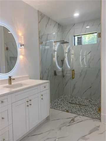 Bathroom with vanity and a shower with door