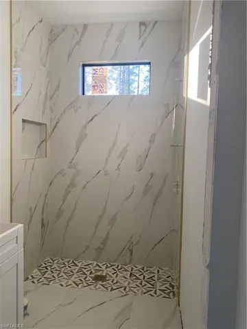 Bathroom featuring a tile shower and vanity