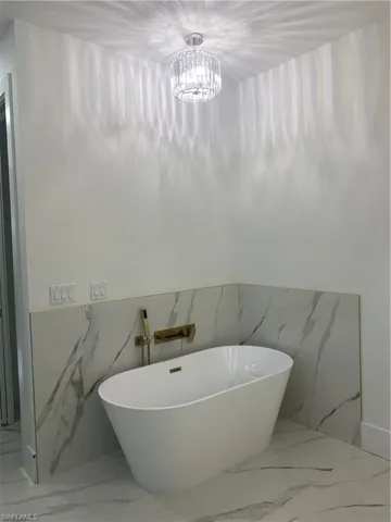Bathroom with a washtub and a chandelier