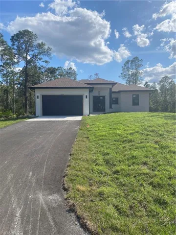 View of front of home featuring a garage and a front yard