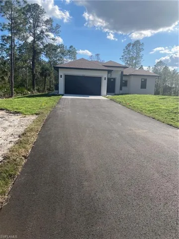 View of front of house with a garage and a front lawn