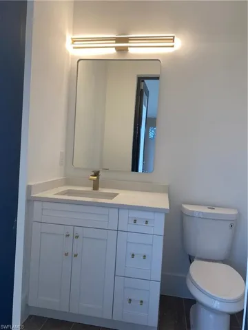 Bathroom featuring tile patterned flooring, vanity, and toilet