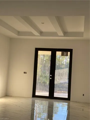 Entryway featuring beamed ceiling and french doors