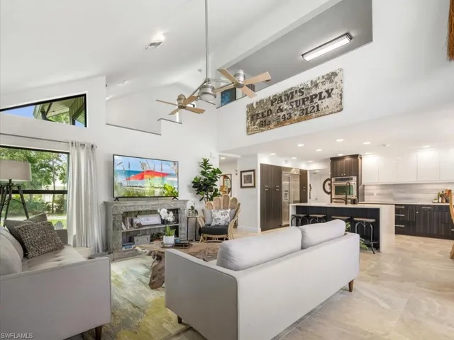 Living room with high vaulted ceiling and view of adjacent kitchen