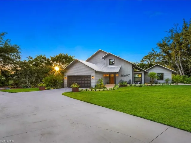 View of front facade featuring a front yard, driveway and a garage
