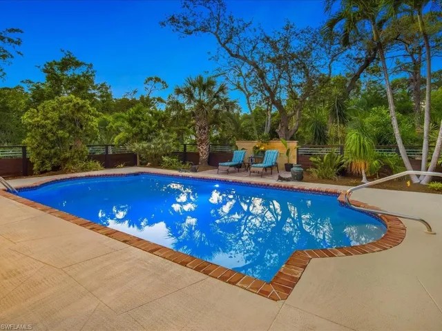 View of pool featuring a patio area, a fenced courtyard, and view of wooded area