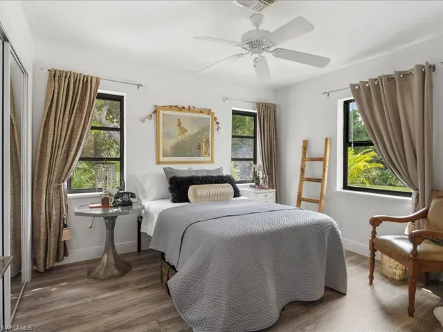 Bedroom with multiple windows, LVP floors, baseboards, and ceiling fan