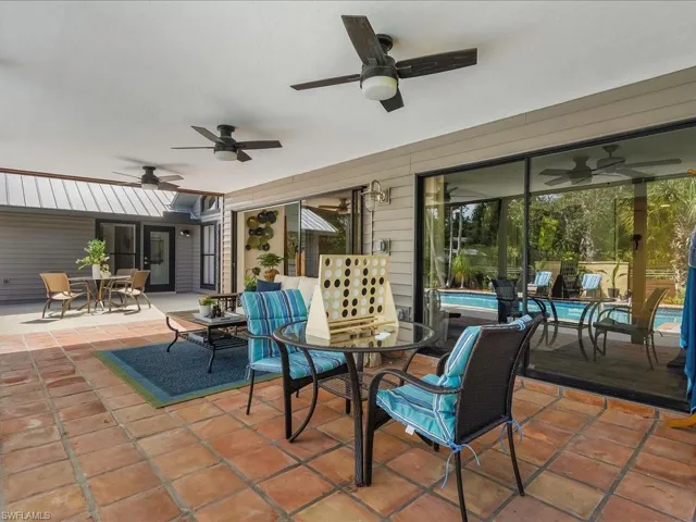 View of patio with a ceiling fan, outdoor dining space, and an outdoor pool