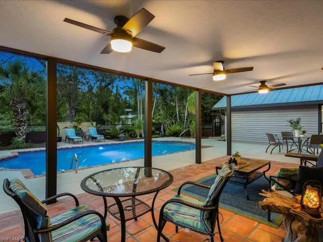Outdoor pool featuring ceiling fan, a fenced courtyard, a patio area, and outdoor dining space