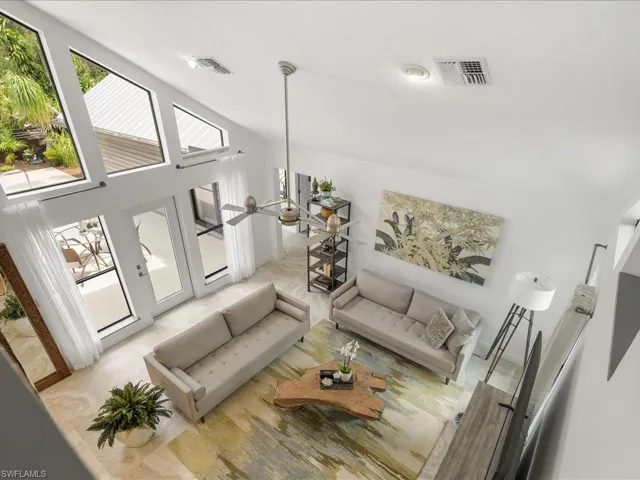 view of living area from upstairs loft featuring a towering ceiling