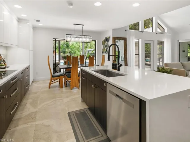 Kitchen with dishwasher, a sink, light countertops, dark brown cabinets, and recessed lighting