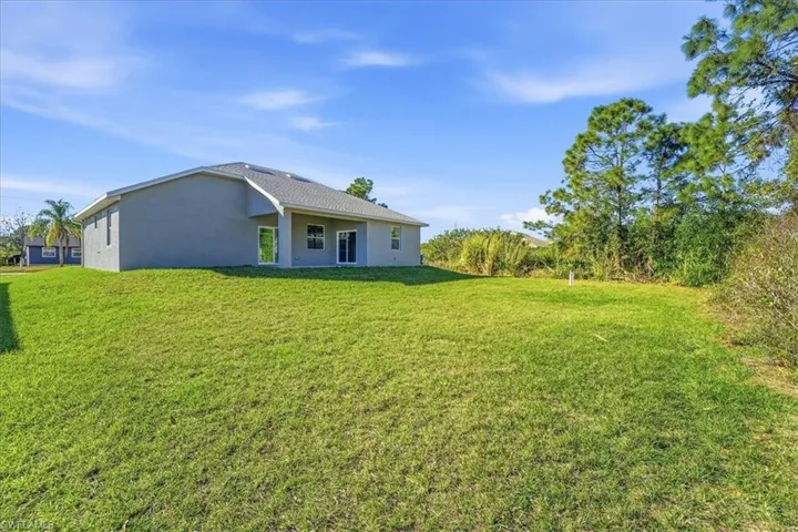 Back of property featuring a yard, stucco siding, and a patio