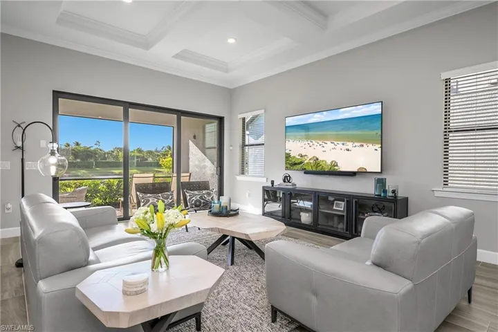 Enjoy seamless indoor and outdoor living with impact sliders leading to the screened lanai and a stunning water and sunset view.