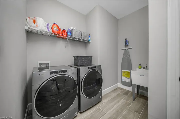 Oversized Laundry Room is spacious and includes a utility sink and upgraded front load appliances.