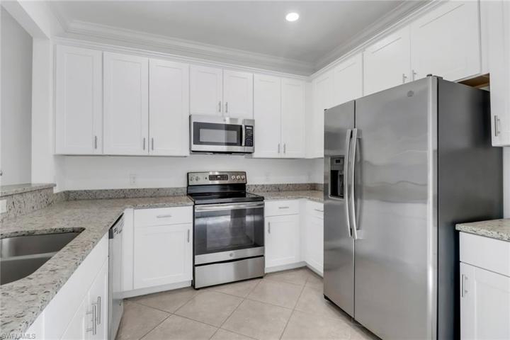 Lovely kitchen boasting white shaker cabinets, granite counters and stainless steel appliances.