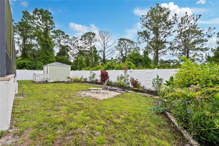 View of yard with a storage shed, an outbuilding, a fenced backyard, and a patio area
