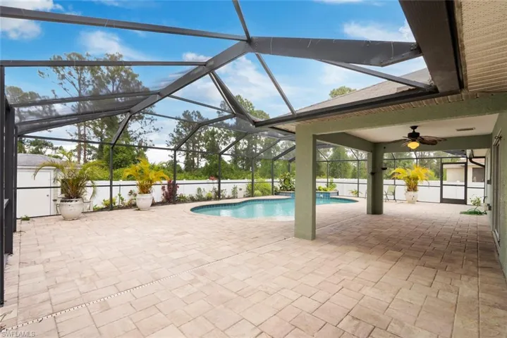 Outdoor pool featuring a patio, ceiling fan, and glass enclosure