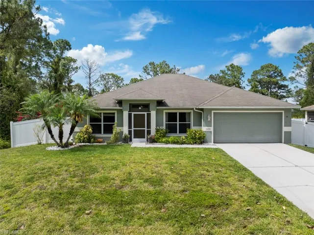 Ranch-style home with a front yard, fence, concrete driveway, an attached garage, and stucco siding