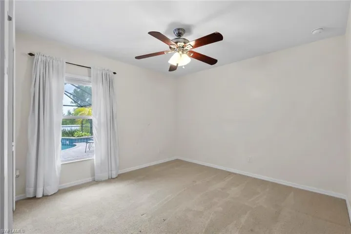 Unfurnished room with carpet flooring, ceiling fan, and baseboards