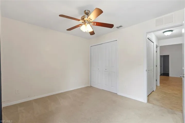 Unfurnished bedroom with visible vents and light carpet