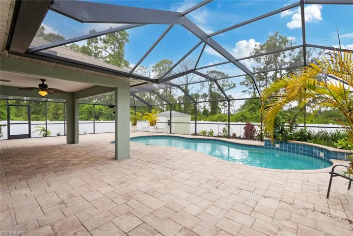 View of pool with a patio, a fenced in pool, a ceiling fan, and an outdoor structure