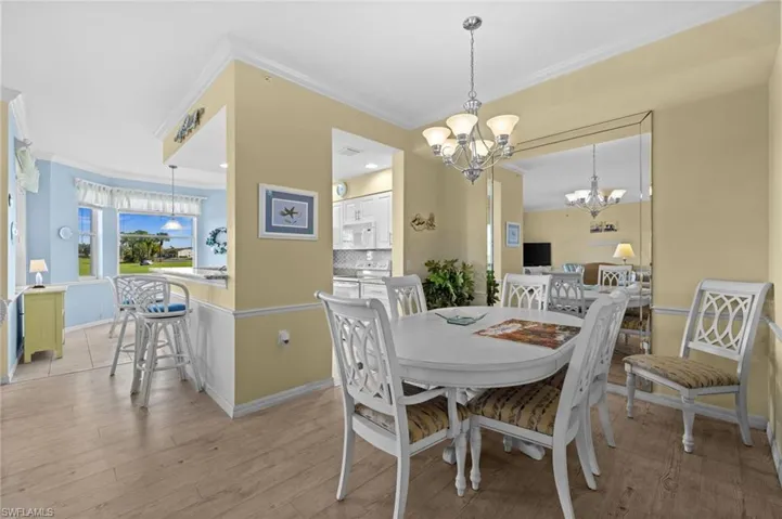 Living area featuring light wood-style floors, ornamental molding, arched walkways, and ceiling fan