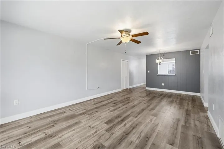 Spacious main living area featuring wood-finish flooring, a ceiling fan, and light gray walls