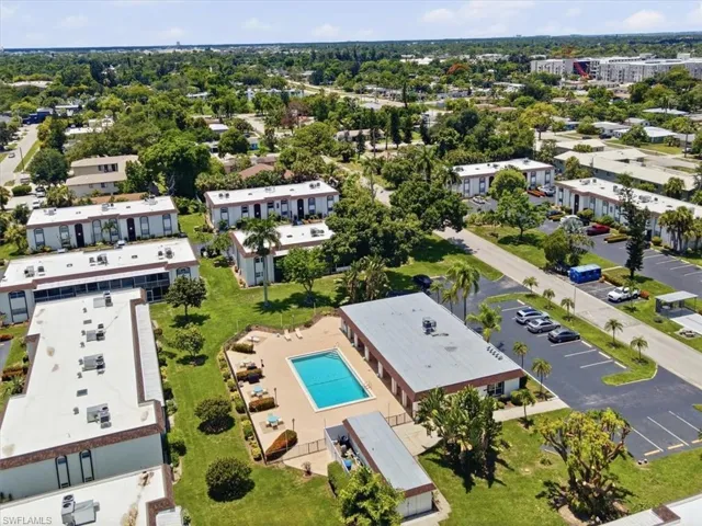 Community pool featuring a surrounding paved deck with lounge chairs and shade umbrellas