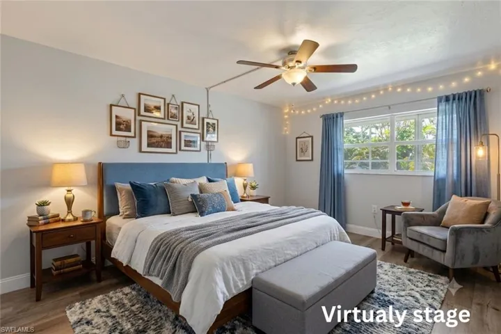Spacious room featuring wood-finish flooring, a ceiling fan, and a large window with natural light