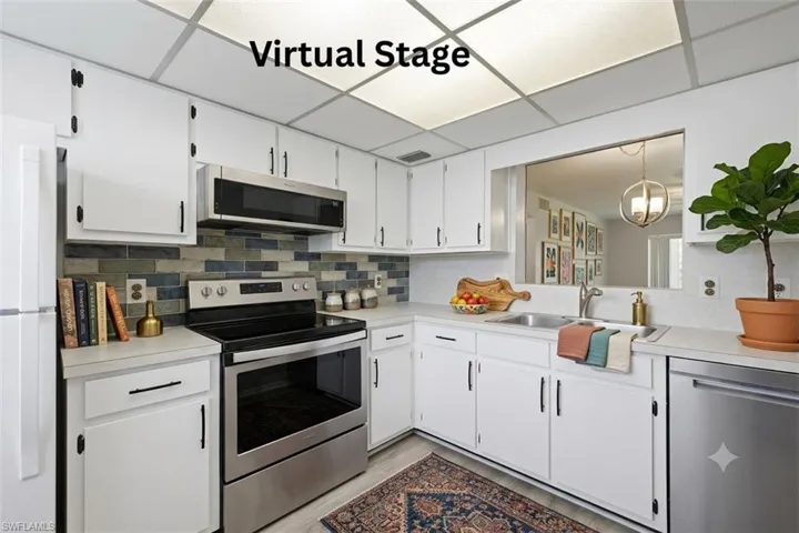 Kitchen featuring white cabinetry with black hardware, stainless steel appliances, and a mosaic tile backsplash