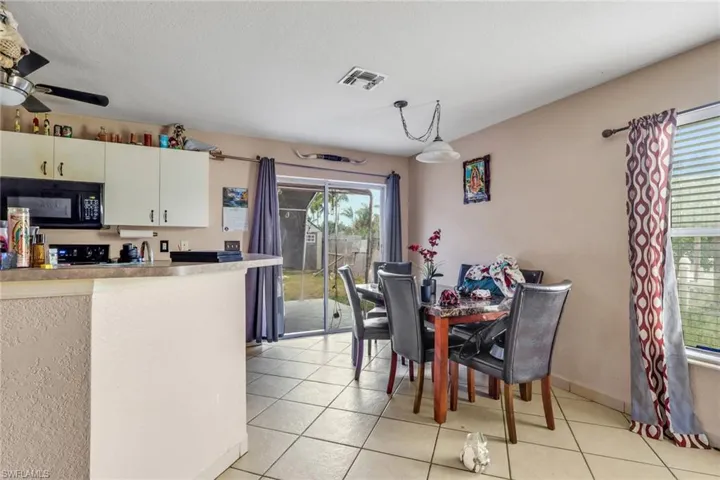 Dining space featuring a ceiling fan and light tile patterned floors