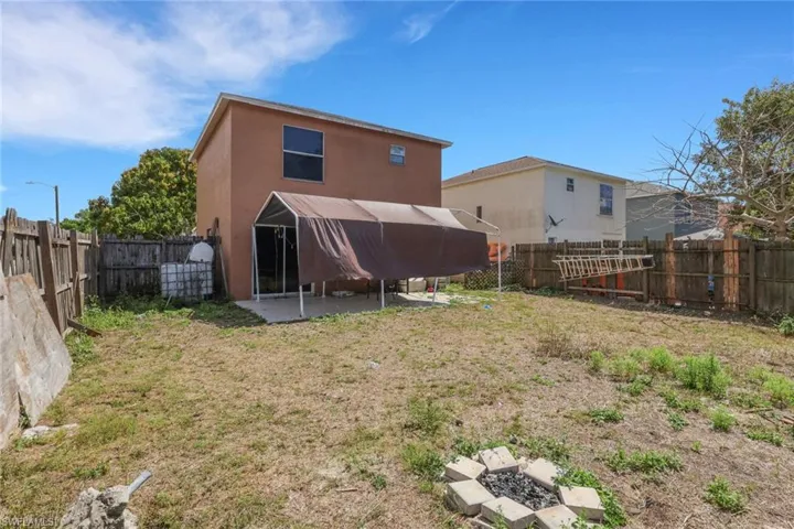 Back of property with a patio area, a fenced backyard, and stucco siding