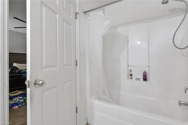 Full bath featuring shower / bath combo, ceiling fan, and a closet