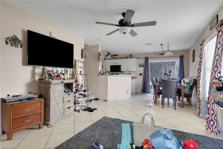 Living room featuring a ceiling fan and light tile patterned floors