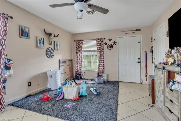 Rec room featuring light tile patterned floors and a ceiling fan
