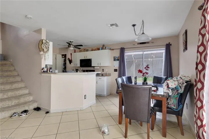 Dining space featuring light tile patterned floors and ceiling fan