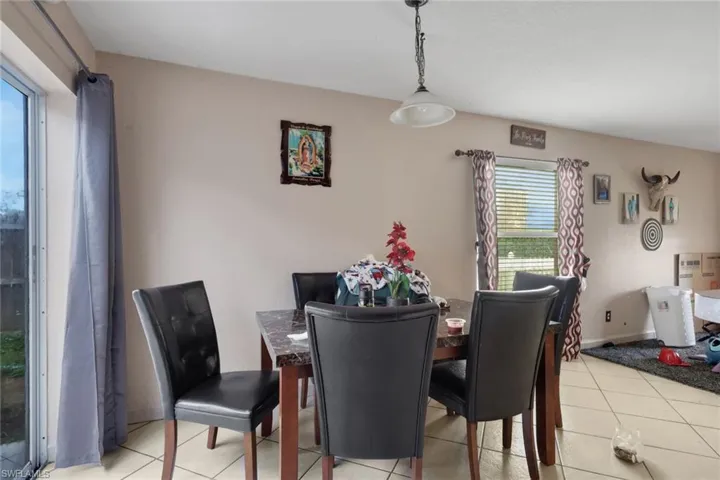Dining space featuring light tile patterned floors and baseboards