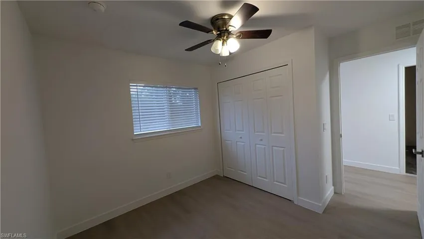 Unfurnished bedroom featuring wood finished floors, ceiling fan, and a closet