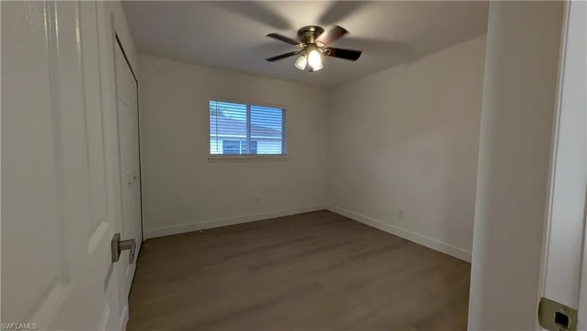 Unfurnished bedroom with wood finished floors, a closet, and a ceiling fan