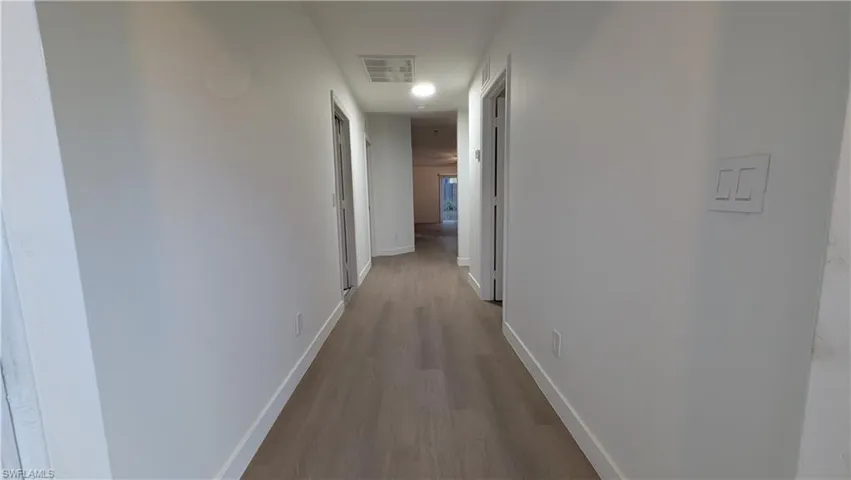 Corridor featuring baseboards and light wood finished floors