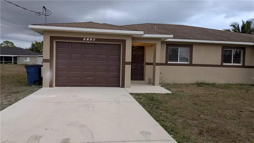 Single story home with a shingled roof, driveway, stucco siding, and a front yard