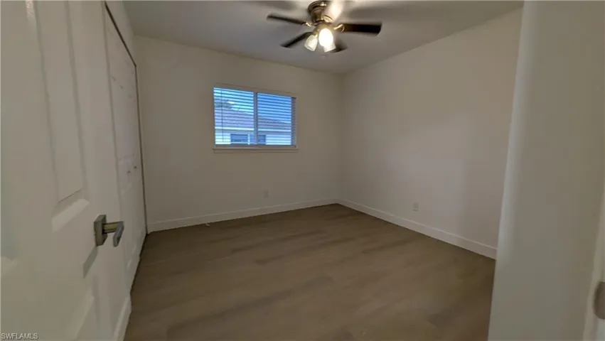 Unfurnished bedroom featuring wood finished floors, a ceiling fan, and a closet