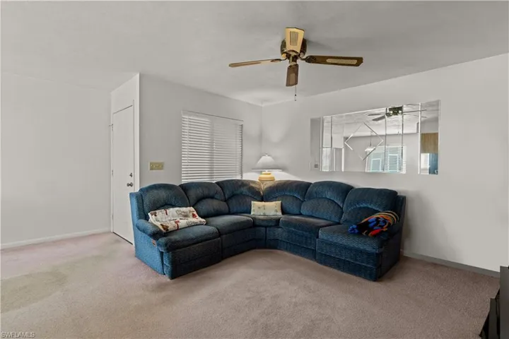 Living room featuring carpet and ceiling fan
