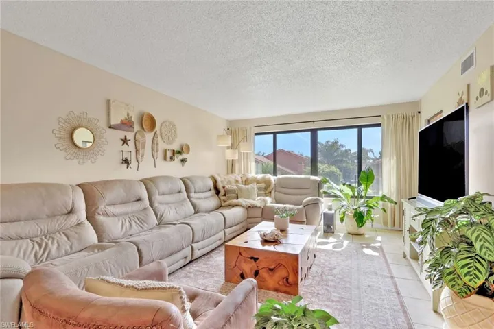 Living area with a textured ceiling and tile patterned floors