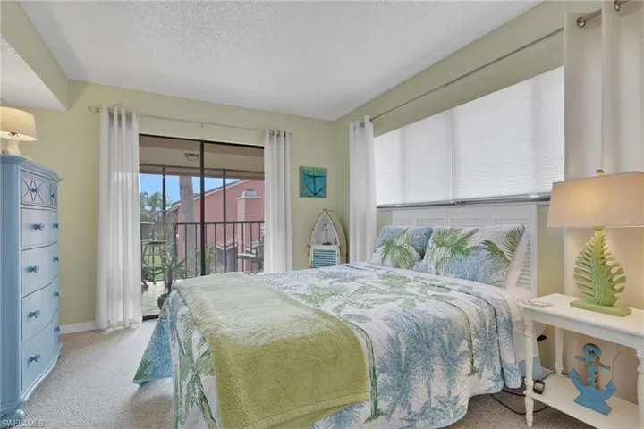 Bedroom featuring carpet flooring, access to exterior, and a textured ceiling
