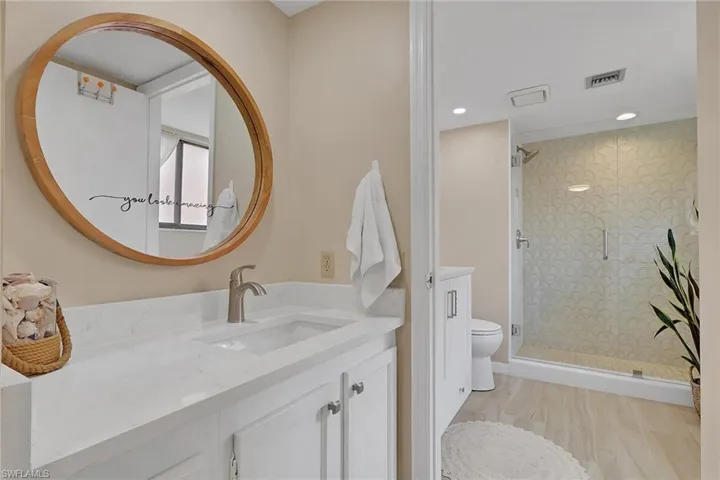 Full bathroom with vanity, a shower stall, and recessed lighting