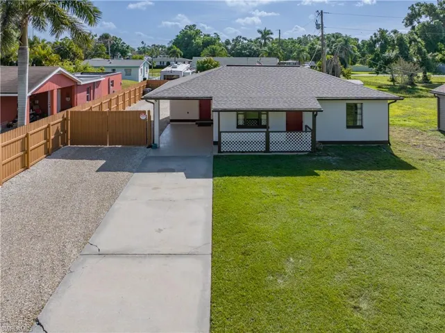 Ranch-style home featuring a carport and a front yard