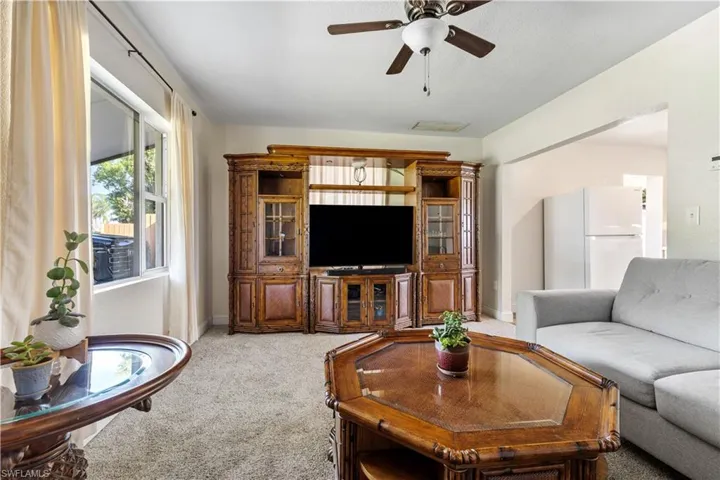Carpeted living room with ceiling fan