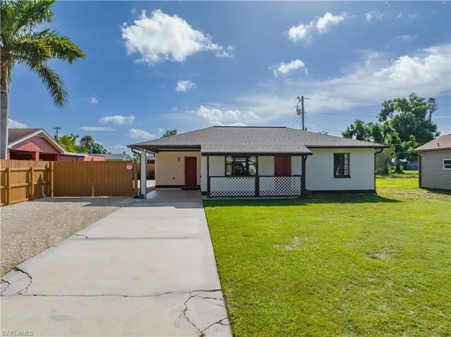 Ranch-style house with a carport and a front lawn
